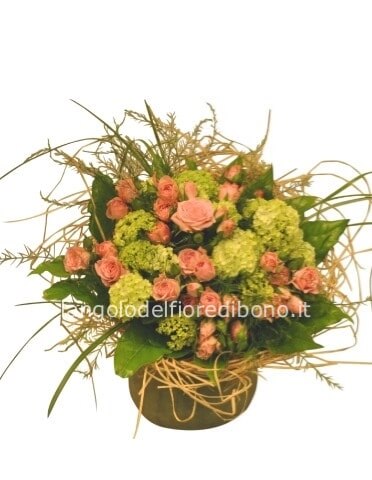 Cestino di vimini o ciotola di ceramica, composto da rose e verde pregiato.